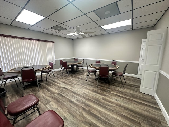 dining area with a paneled ceiling, ceiling fan, and dark wood-type flooring