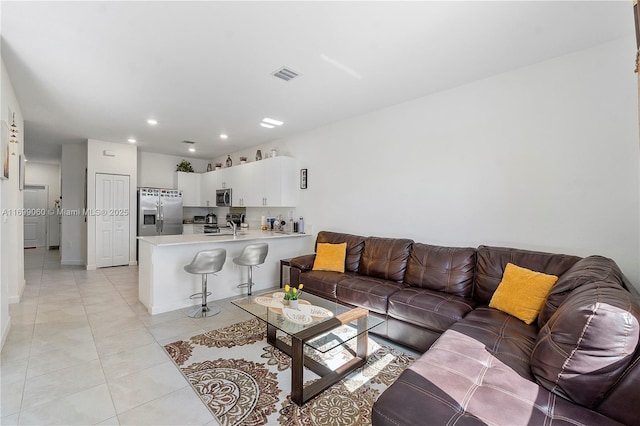 living room featuring sink and light tile patterned floors