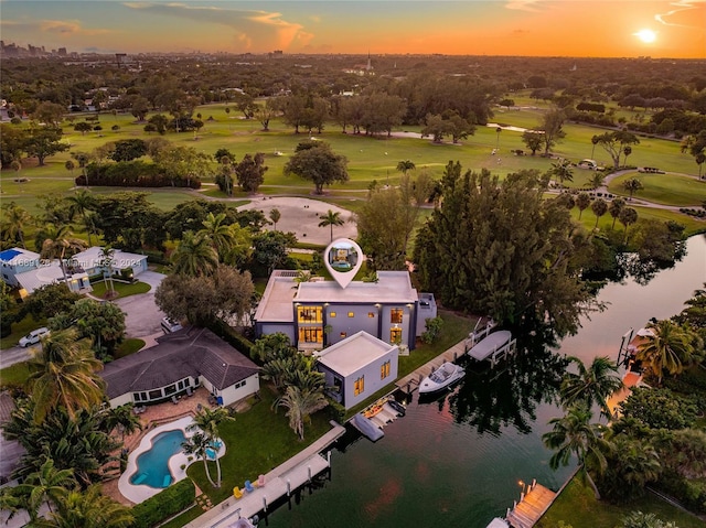 aerial view at dusk featuring a water view