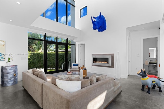 living room featuring french doors, a towering ceiling, and sink