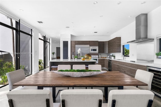 dining area with wine cooler, a wall of windows, and sink