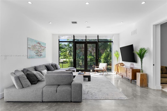 living room featuring expansive windows, concrete flooring, and french doors