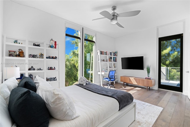 bedroom featuring ceiling fan, light wood-type flooring, access to outside, and multiple windows