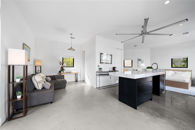 kitchen with concrete flooring, pendant lighting, ceiling fan, and a spacious island