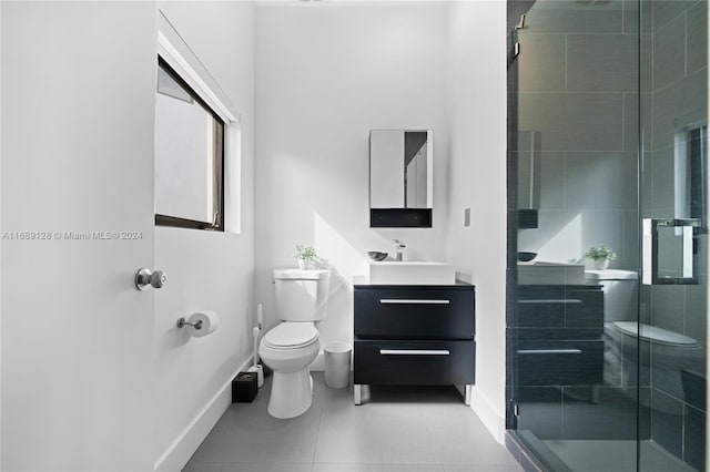 bathroom with tile patterned floors, vanity, toilet, and an enclosed shower