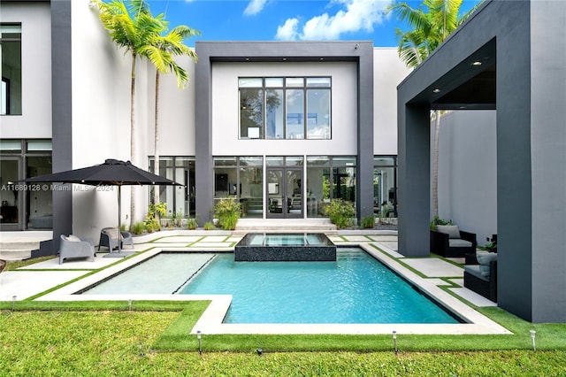 rear view of property with a swimming pool with hot tub, french doors, and a patio area