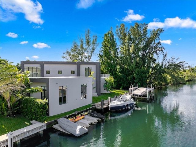 rear view of house featuring a yard and a water view