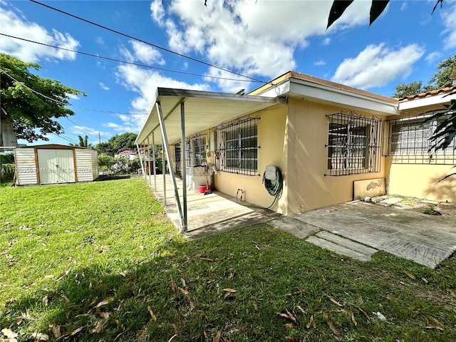 exterior space with a patio area, a yard, and a storage shed