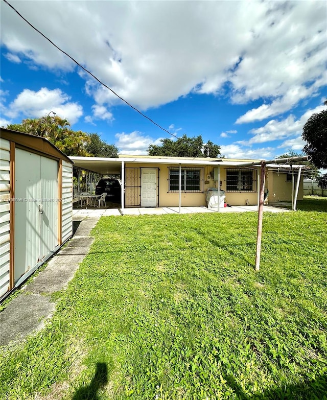 rear view of house featuring a carport, a storage shed, and a yard