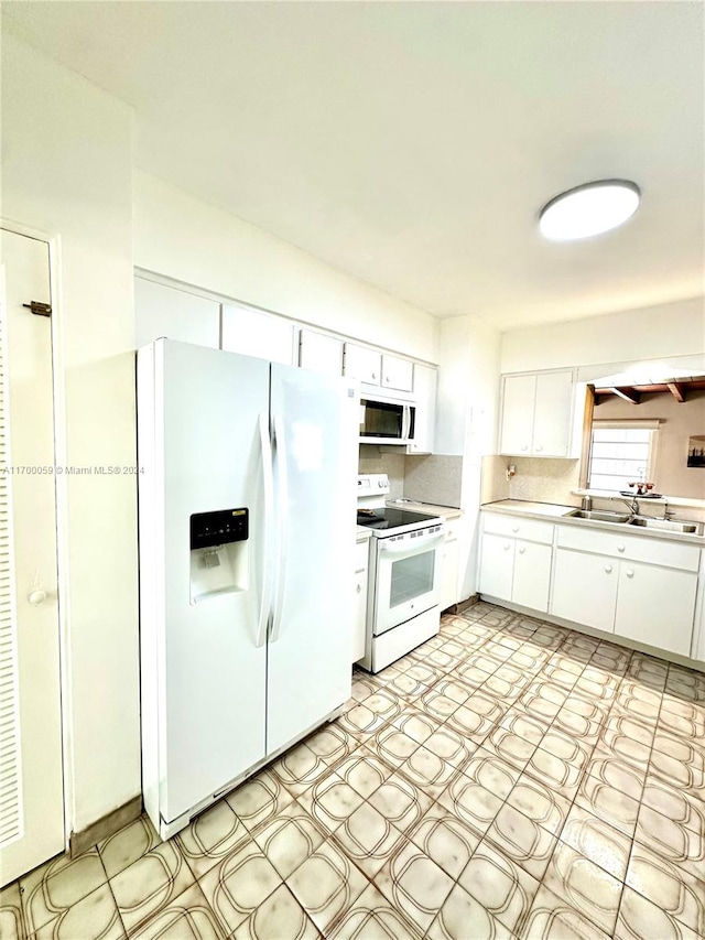 kitchen featuring white cabinets, white appliances, sink, and tasteful backsplash