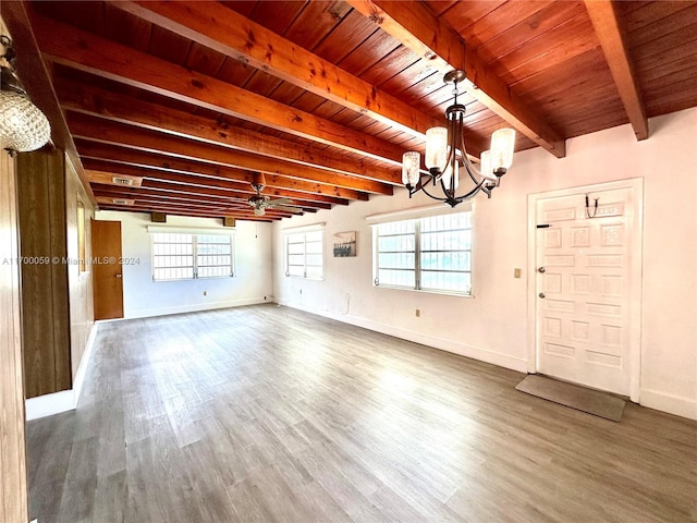 interior space with ceiling fan with notable chandelier, beam ceiling, dark hardwood / wood-style flooring, and plenty of natural light