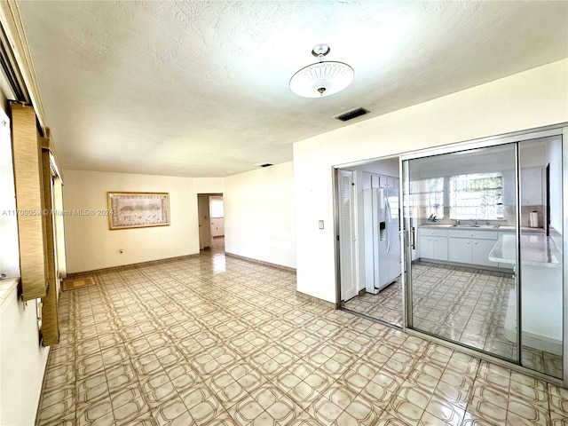 unfurnished room featuring a textured ceiling and sink