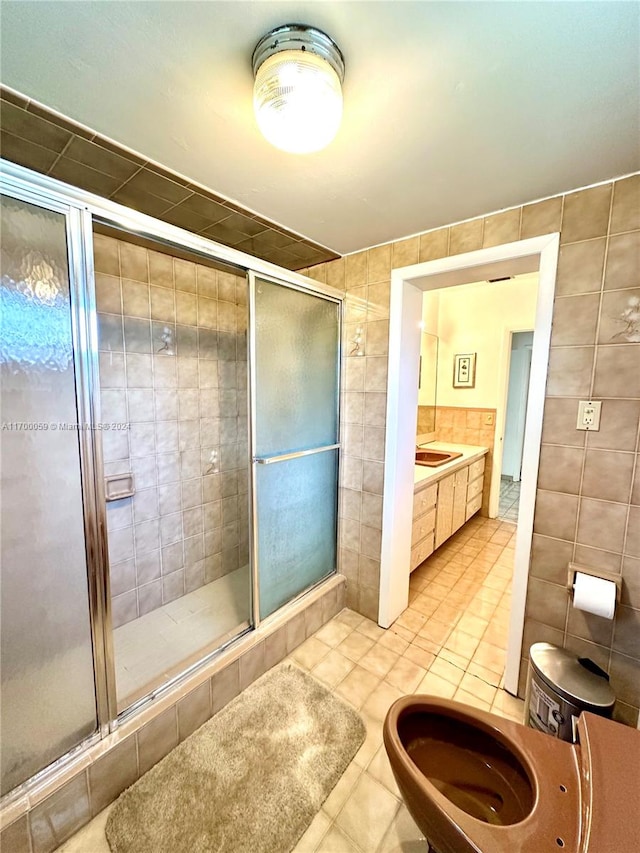 bathroom with tile patterned flooring, tile walls, and walk in shower