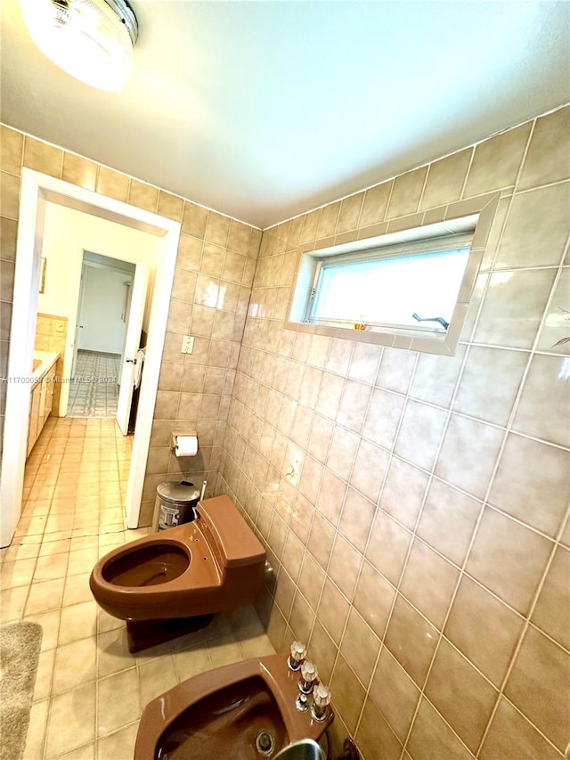 bathroom featuring a bidet, tile patterned floors, and tile walls