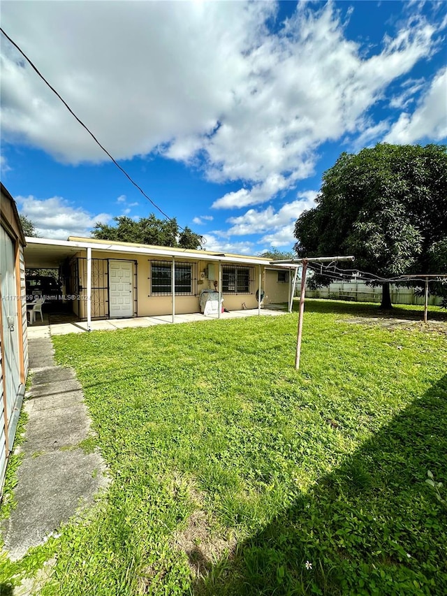 rear view of property featuring a yard and a carport