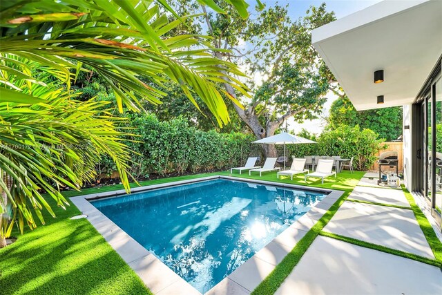 view of swimming pool with a patio and an outdoor fireplace