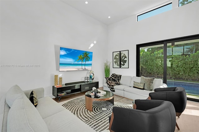 living room featuring a towering ceiling and hardwood / wood-style floors