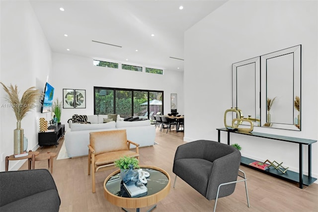 living room featuring a high ceiling and light wood-type flooring