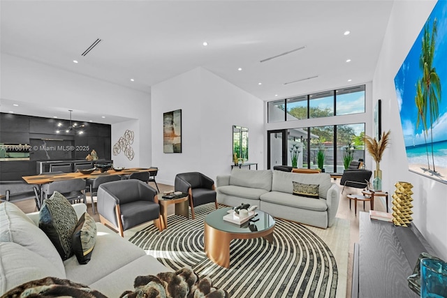 living room with hardwood / wood-style flooring and a towering ceiling