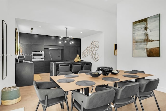 dining room with a notable chandelier and light hardwood / wood-style floors