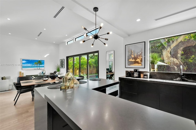 kitchen with hanging light fixtures, sink, and light hardwood / wood-style floors