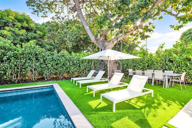 view of swimming pool with a lawn