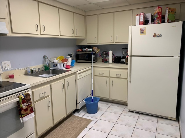 kitchen featuring sink, light tile patterned floors, white appliances, and cream cabinets