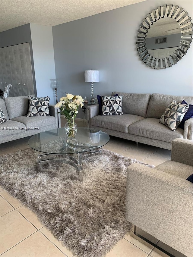 living room with tile patterned floors and a textured ceiling