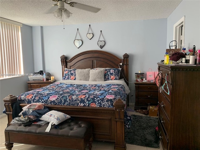 tiled bedroom with ceiling fan and a textured ceiling