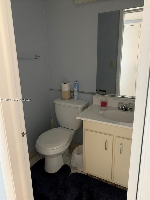 bathroom featuring tile patterned flooring, vanity, and toilet