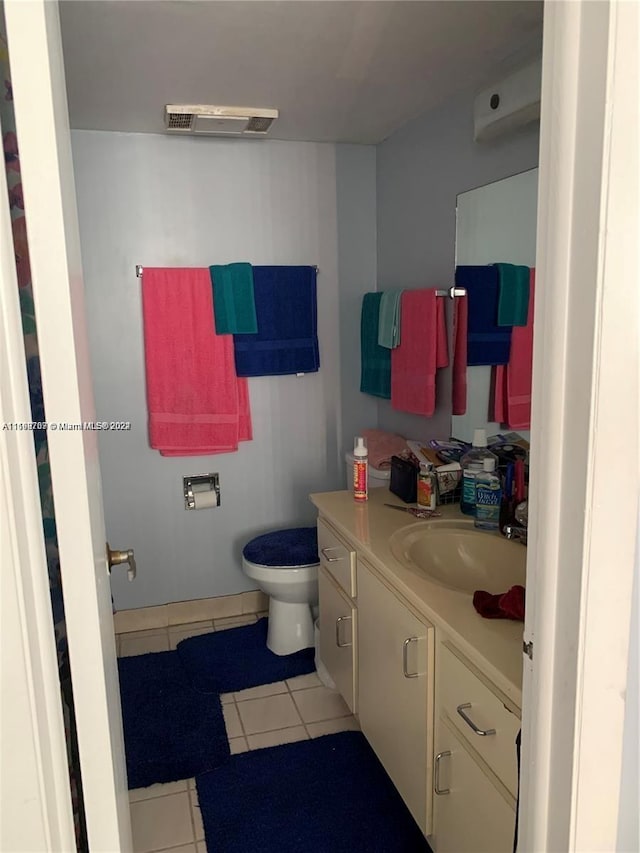 bathroom with tile patterned flooring, vanity, and toilet