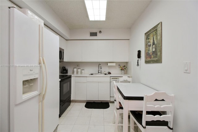 kitchen featuring white cabinets, white appliances, sink, and light tile patterned floors