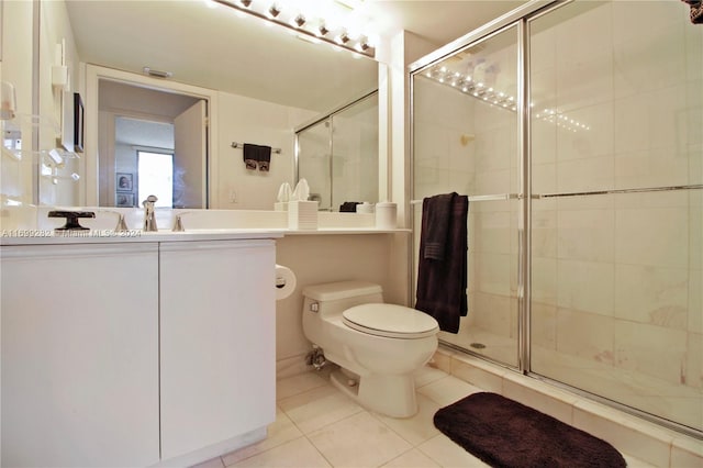 bathroom featuring tile patterned flooring, vanity, toilet, and a shower with shower door