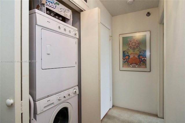 washroom featuring light carpet, a textured ceiling, and stacked washer / drying machine