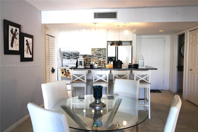 dining space featuring tile patterned flooring and a textured ceiling