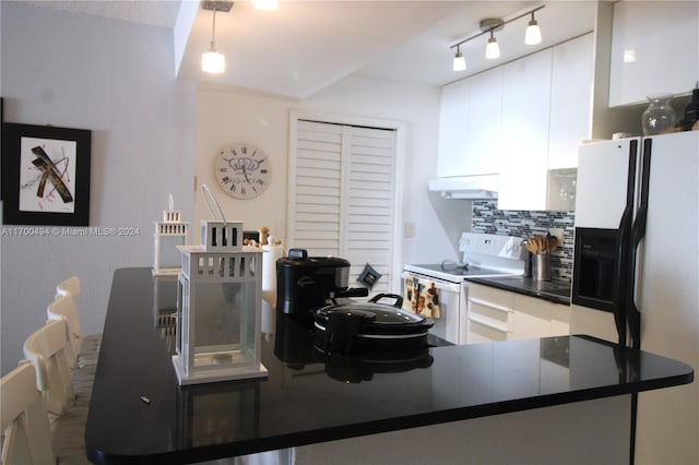 kitchen featuring tasteful backsplash, white cabinetry, exhaust hood, and white appliances