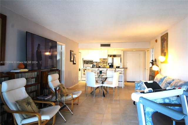 tiled living room featuring a textured ceiling