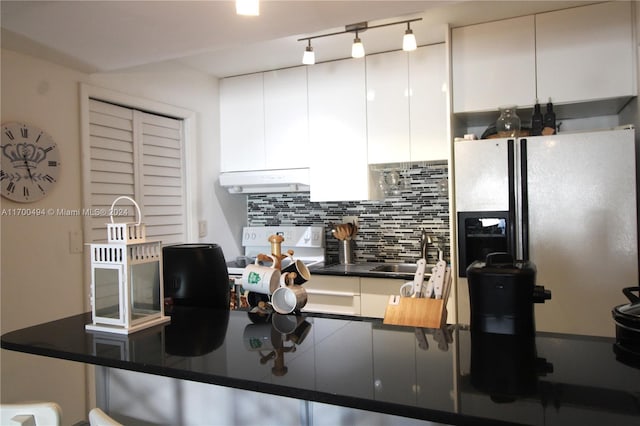kitchen featuring backsplash, sink, black fridge with ice dispenser, white cabinetry, and extractor fan