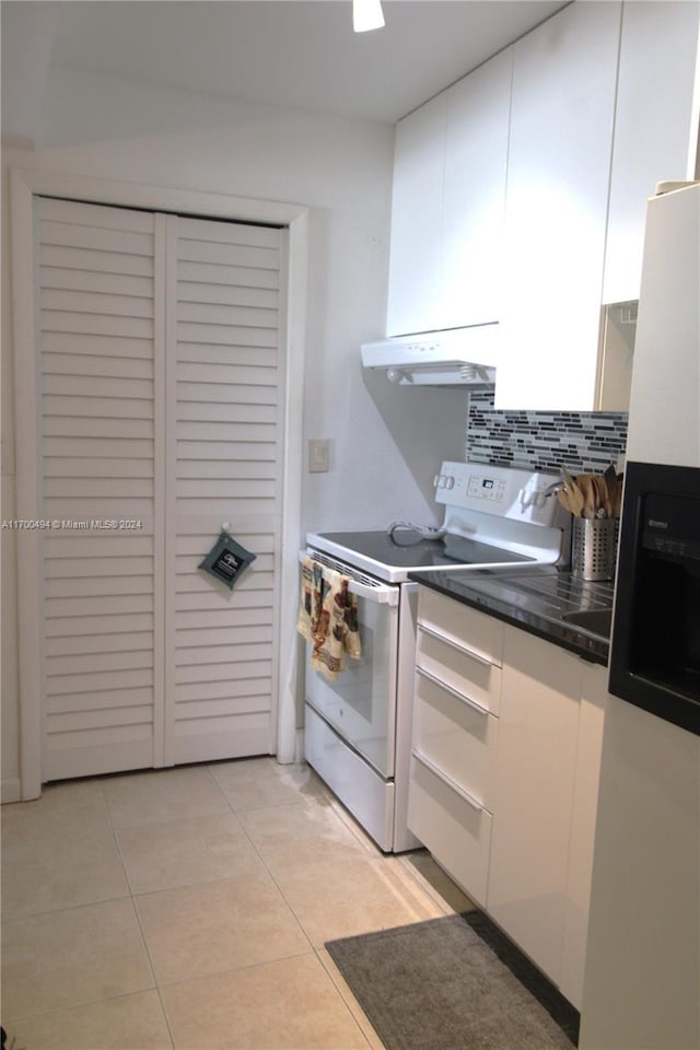 kitchen featuring white cabinetry, range hood, white appliances, decorative backsplash, and light tile patterned floors