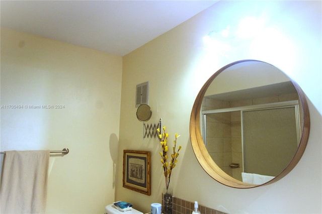 interior details with toilet and a shower with shower door