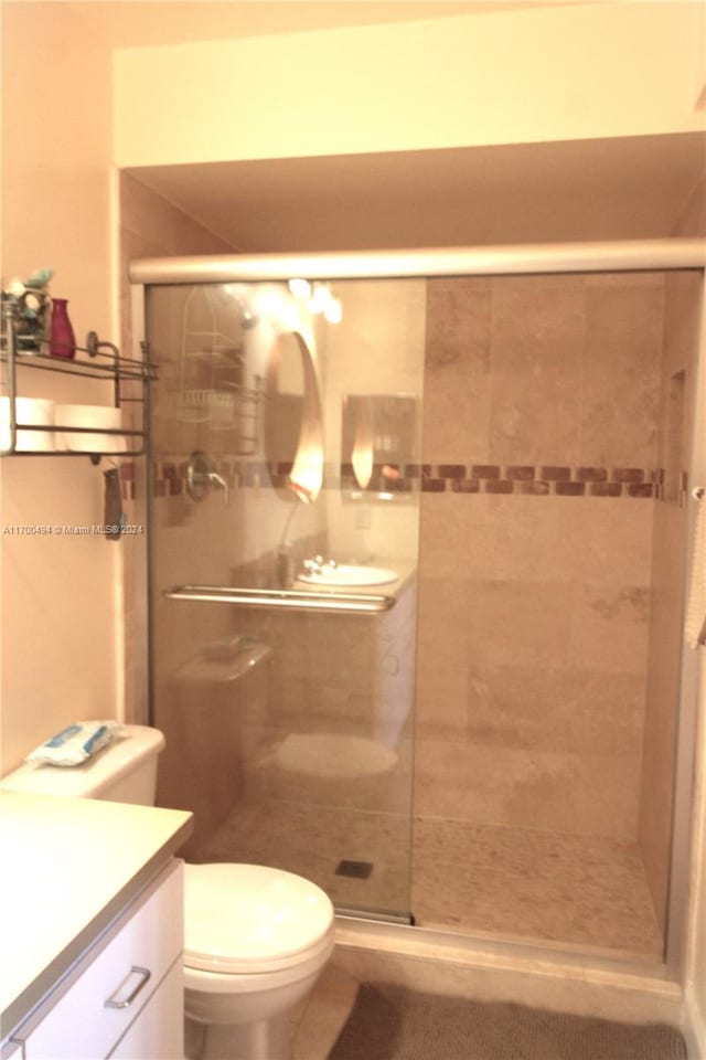 bathroom featuring walk in shower, vanity, and toilet