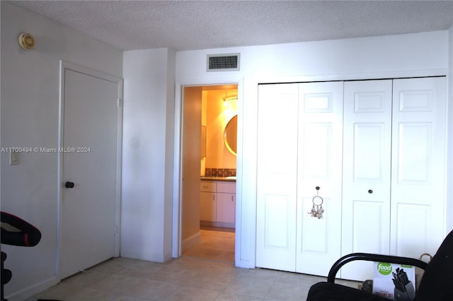 interior space featuring a textured ceiling and light tile patterned flooring