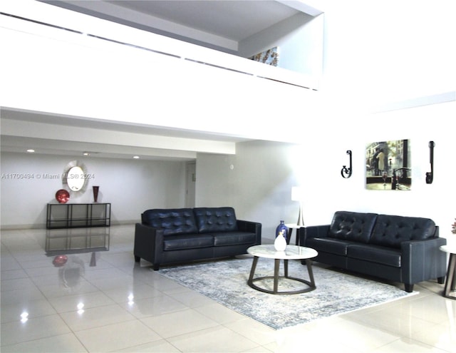 living room featuring light tile patterned flooring and a towering ceiling