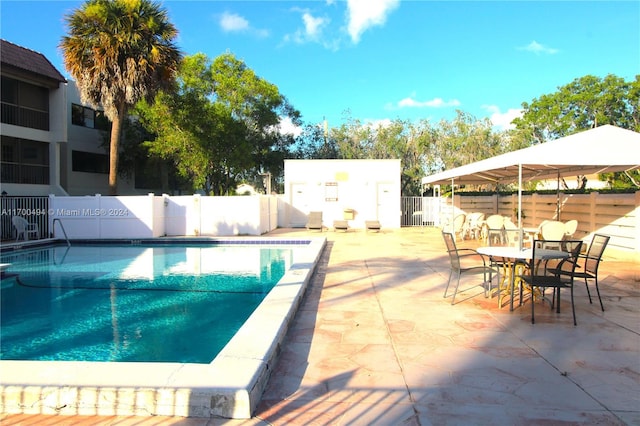 view of pool featuring a patio area and an outbuilding