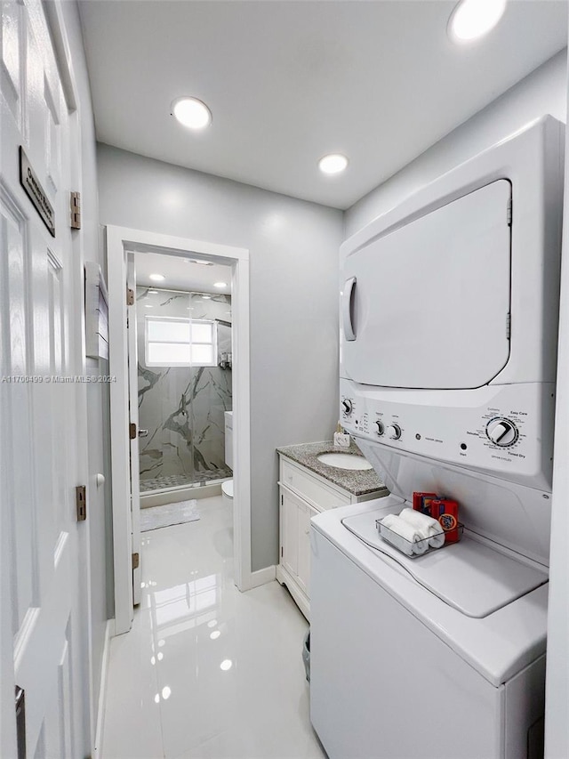 laundry area with light tile patterned flooring and stacked washer and clothes dryer