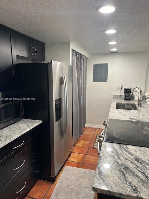 kitchen with light stone countertops, a textured ceiling, electric panel, and sink