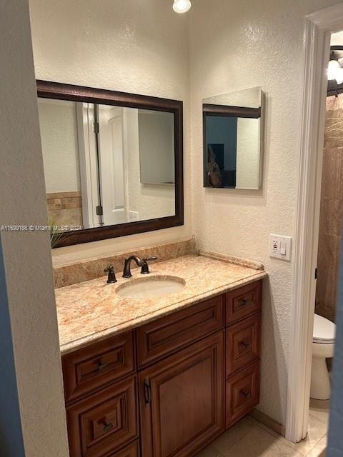 bathroom with tile patterned flooring, vanity, and toilet