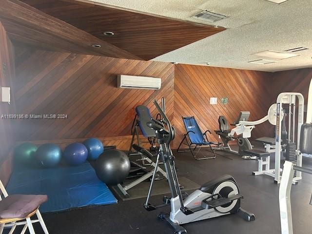 exercise room featuring wood walls and a wall mounted air conditioner