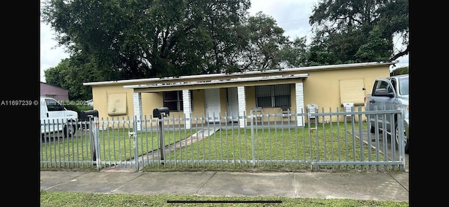 view of front of property featuring a porch, a front lawn, a fenced front yard, and stucco siding