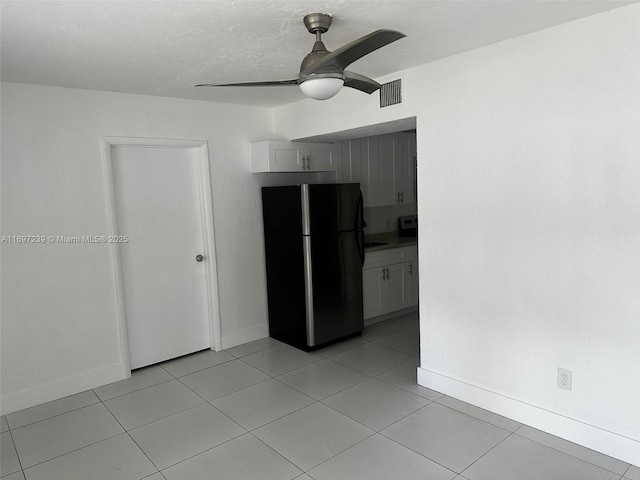 kitchen with baseboards, freestanding refrigerator, a ceiling fan, and visible vents